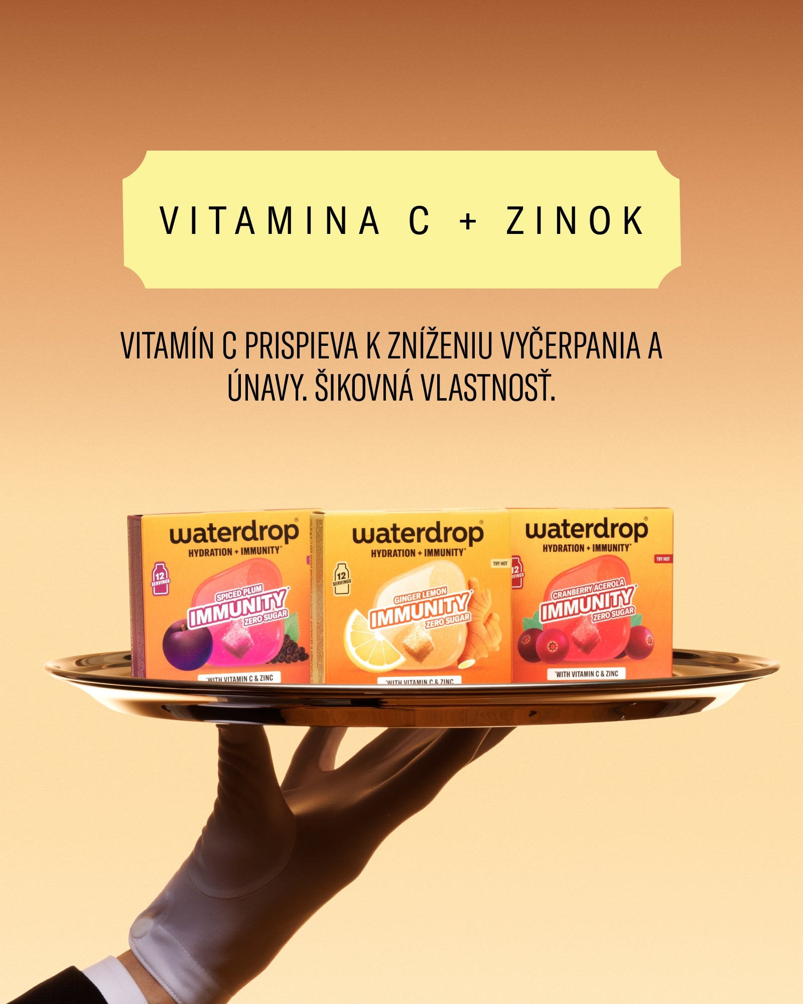 Ruka drží tác s tromi krabičkami nápoja s vitamínom C a zinom.